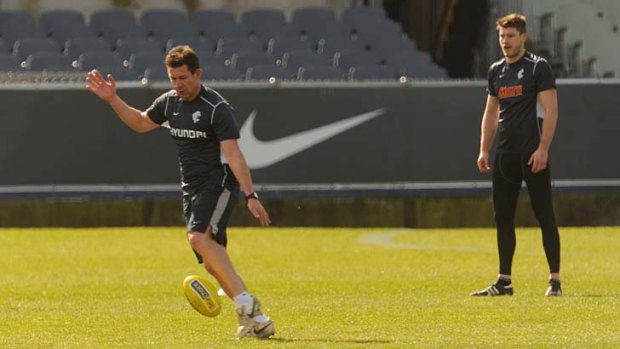 Getting a kick: Carlton coach Brett Ratten relaxes at training yesterday while Bryce Gibbs assesses his style.