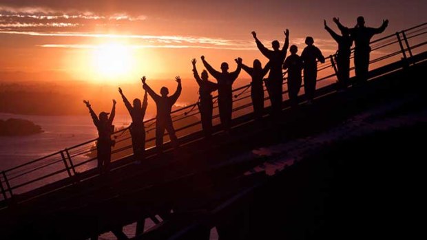 Climbers cheer their efforts at the top of the bridge at dawn.
