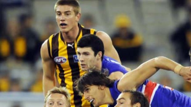 Hawk Sam Mitchell has plenty of Bulldog company but manages to get the ball clear.