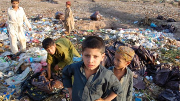 Life on the edge ... Afghan refugees sift through rubbish from one of Islamabad's five-star hotels.