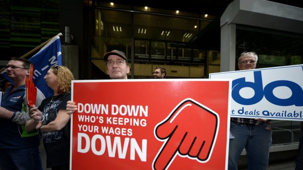 Meatworkers union members protest outside the shop assistants' union over its wages deal with Coles.