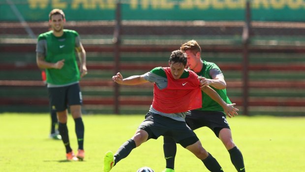 Working: Mark Milligan contests possession in Socceroos training.