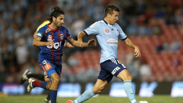 Fine form: Milos Dimitrijevic of Sydney FC keeps the ball from Newcastle's Zenon Caravella.
