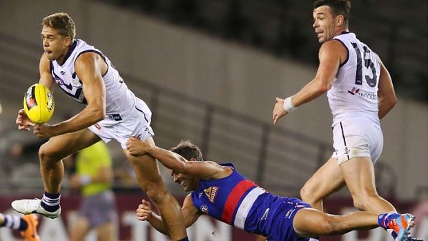 Shaun Higgins of the Bulldogs tackles Stephen Hill of the Dockers.