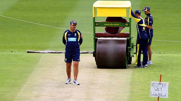 Australia's Coach Mickey Arthur (C) inspects the contentious First Test wicket.