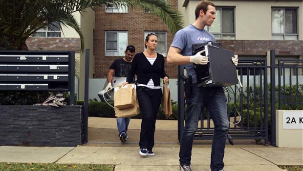 Victim: Police carrying evidence leave the block where Henry Kwan fell to his death.