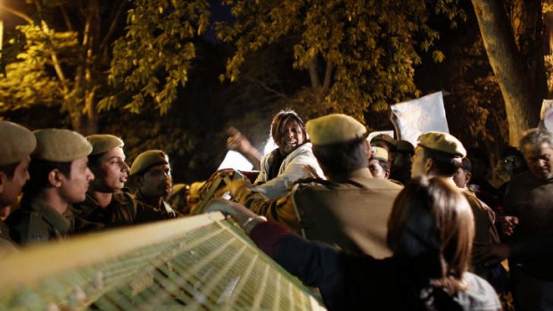 Indian police try to calm a protestor.