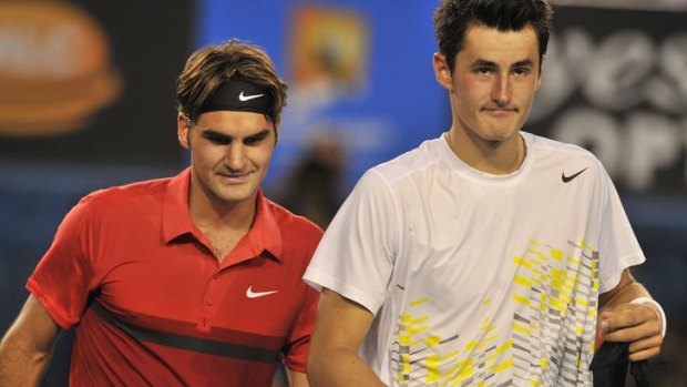 Victor and vanquished: Roger Federer and Bernard Tomic walk off the court after their match last night.