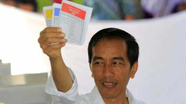 Widespread popularity ... Jakarta governor and presidential candidate from the Indonesian Democratic Party-Struggle (PDI-P) party, Joko Widodo, shows his ballot paper during voting in the parliamentary elections in Jakarta on Wednesday.
