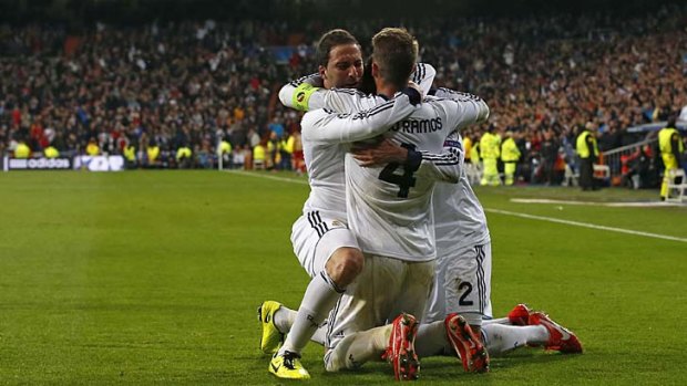 Real Madrid's Gonzalo Higuain (L) celebrates his goal against Galatasaray with captain Sergio Ramos ( C ) and Raphael Varane.