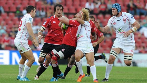 Willie Britz of the Lions is tackled by Quade Cooper at Ellis Park.