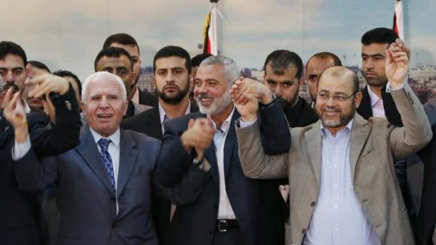 Together after seven-year split ... senior Fatah and Hamas leaders hold their hands after announcing a reconciliation agreement in Gaza City.