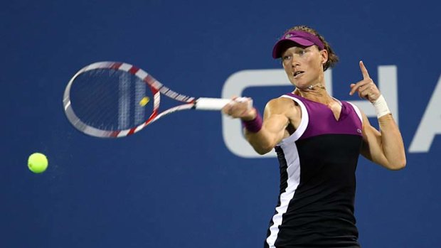 Samantha Stosur of Australia returns a shot against  Nadia Petrova of Russia during Day Five of the 2011 US Open.