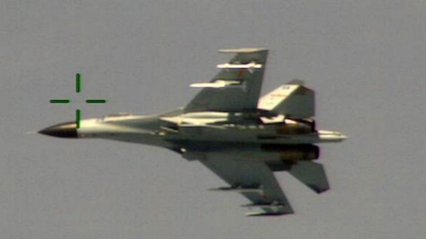 Dangerous intercept: The Chinese fighter jet performs a barrel roll, apparently to show off its weapons.