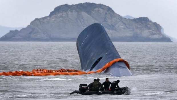 A vessel involved in salvage operations passes near the upturned South Korean ferry Sewol.