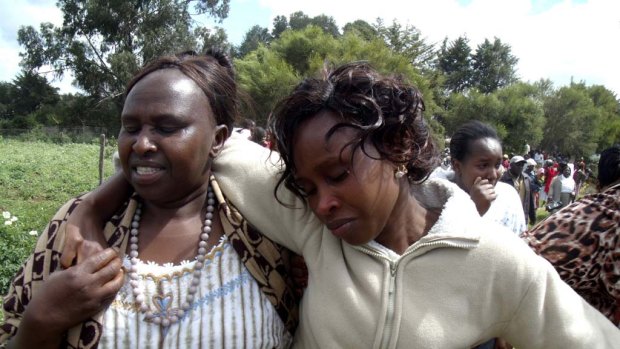 Triza Njeri, right, Samuel Wanjiru's widow,  is helped  after viewing his body at a funeral home.