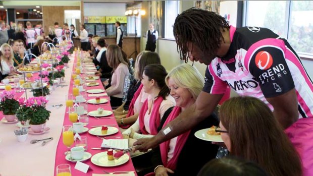 Pink service ... Tigers winger Lote Tuqiri serves breakfast at Leichhardt Oval yesterday at the launch of the Women in League round to be held later this month.