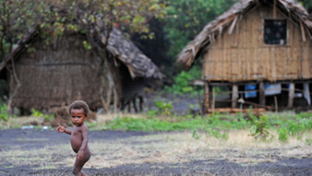 A child walks on the black sand of Sulphur Bay on the slopes of Mount Yasur volcano.