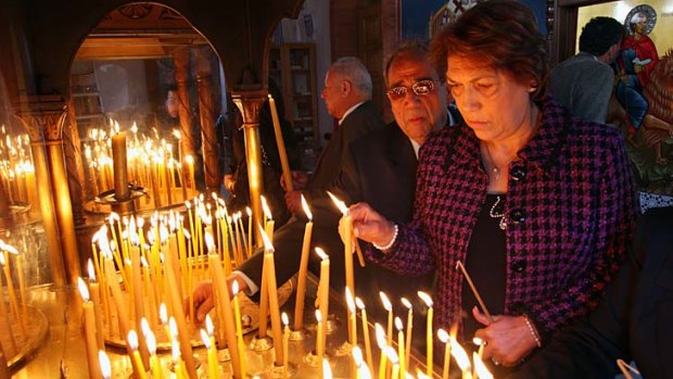 Praying for a fiscal lifejacket: Cypriots light candles during a Sunday service at Saint Mamas Orthodox church in Nicosia, Cyprus.