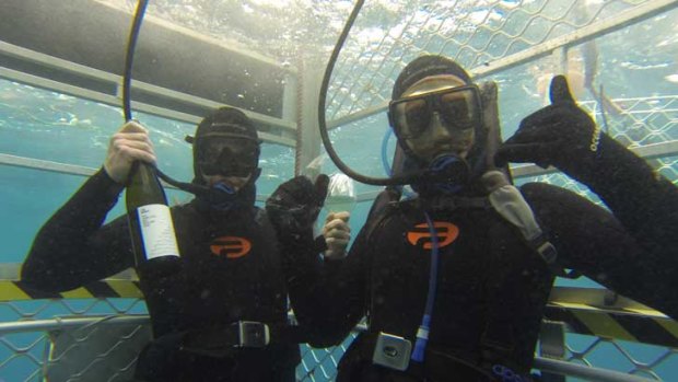 Winemaker Tom Barry and travelling Wineram presenter and sommelier Colin West taste Clare Valley riesling in a shark cage off Port Lincoln, South Australia. <i>Photo: Rupert Critchley</i>