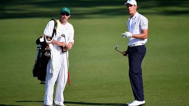Oliver Goss of Australia and his caddie Brian Tam on the second fairway during the second round of the 2014 Masters Tournament.