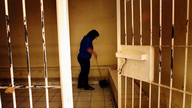 A woman cleans the holding cell at the Denpasar courthouse.