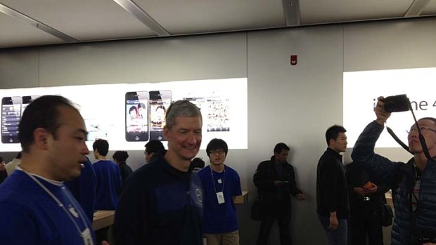 Apple CEO Tim Cook talks to employees at an Apple store in Beijing.