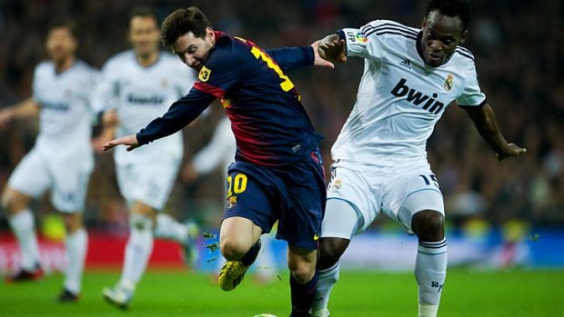 Lionel Messi (L) of Barcelona duels for the ball with Michael Essien of Real Madrid.