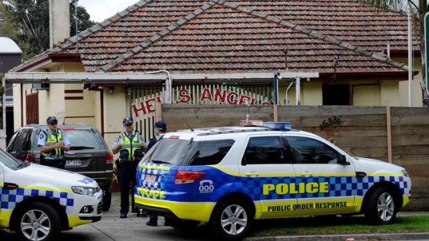 Police officers stand outside the Hells Angels property in Alphington.