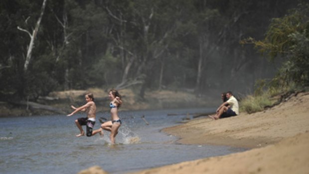 Travis and Emma Anderson take the plunge at Cobram's Thompsons Beach yesterday, despite an extreme threat of toxic algal blooms.