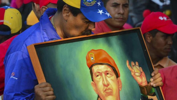 Chosen heir: Acting president Nicolas Maduro kisses a picture of his late predecessor Hugo Chavez at a campaign rally.