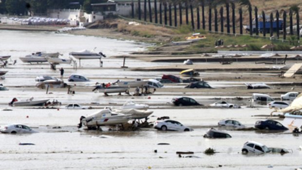 Partially submerged cars are seen next to boats after heavy rains flooded the town of Silivri.
