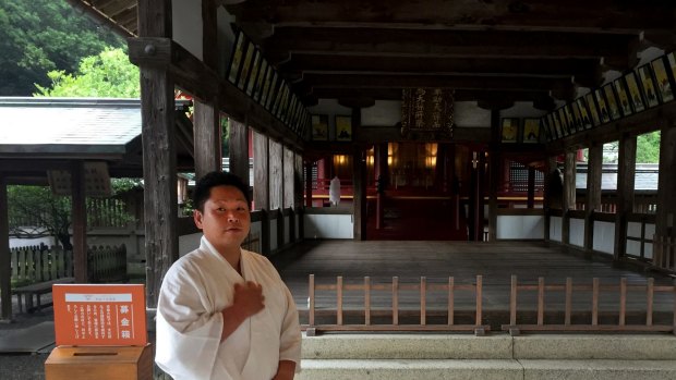 Yoshihiro Suzuki, a 32 year-old Shinto priest, poses at the Munakata Taisha shrine in Okinoshima, Japan.