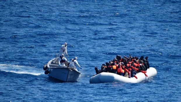 The Italian Navy approach a dinghy filled with migrants in the Mediterranean Sea in March.