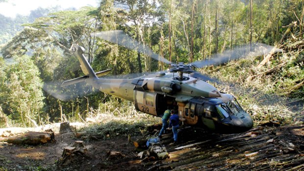 A Black Hawk helicopter lands at the crash site.