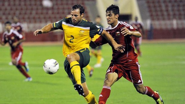 Oman's Abdulaziz Almkabbala (right) challenges Australia's Lucas Neill during the Asian qualifiers for the 2014 World Cup, in Muscat.