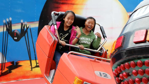 Ticket to ride: Teenagers Sievheang Soeun and Thrim Khat, who have been hosted by Central Coast Grammar School, at Luna Park.