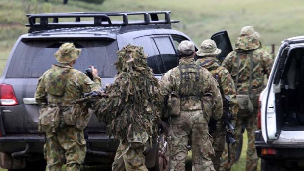 Ready for the hunt ... a specialist police group dressed in camouflage preparing to leave Nowendoc yesterday to search for Malcolm Naden.