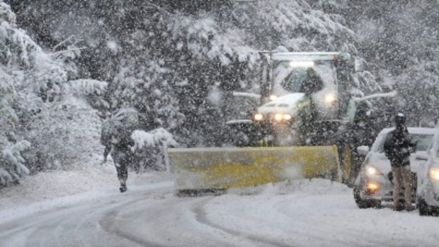 A tractor clears snow on State Highway 94 south of Te Anau as stranded tourists wait for the road to be cleared during heavy morning snow on state Highway 94.