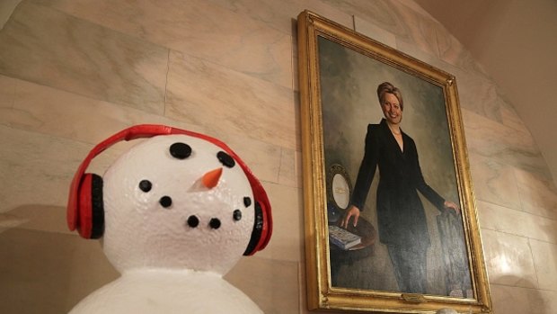 A snow man chills next to a portrait Hillary Clinton in the White House.