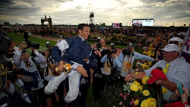 Moment of glory ... Nick Williams, owner of Green Moon, picks up jockey Brett Prebble after he stormed home to take out the Melbourne Cup yesterday.