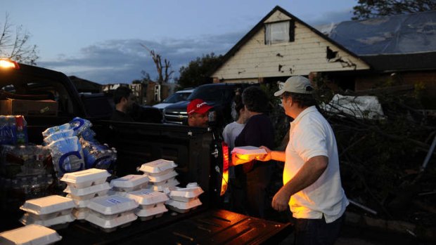 Comfort food: Derick Brock, from Mercy Chefs, distributes hot dinners to tornado victims in the devastated neighbourhood of Moore.