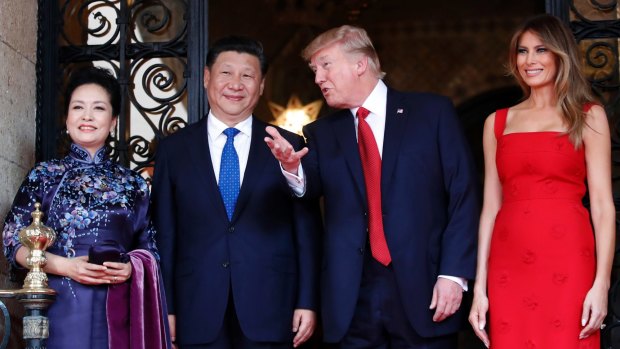 President Donald Trump talks with Chinese President Xi Jinping, with their wives, first lady Melania Trump and Chinese first lady Peng Liyuan as they pose for photographers before dinner at Mar-a-Lago.