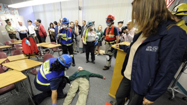 Emergency workers practice aiding 'injured' students during California's earthquake drill.