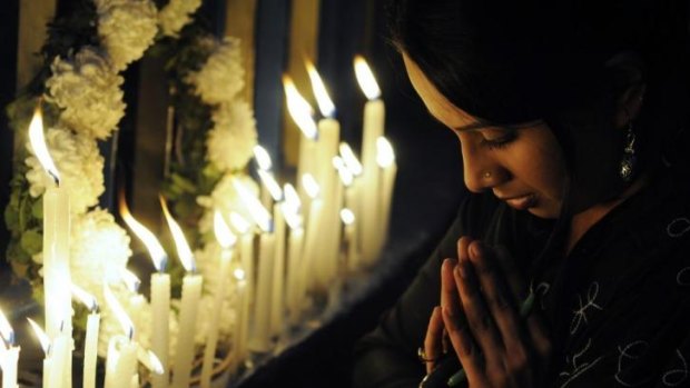 An Indian activist prays as she takes part in a candlelight vigil in Kolkata after the cremation ceremony for a gang-rape victim on December 30, 2012.