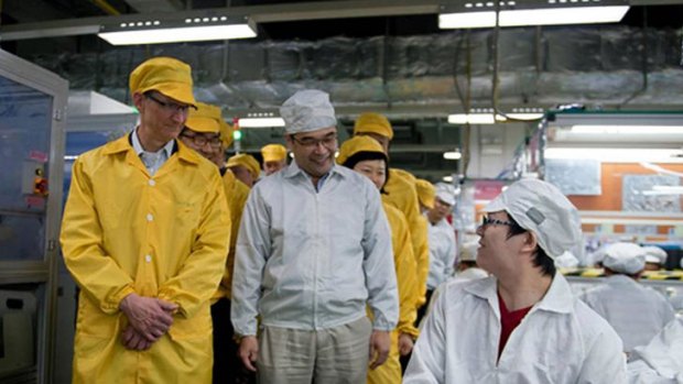 This handout picture released by Apple and taken on March 28, 2012 shows Apple chief executive Tim Cook (L) visiting the iPhone production line at the newly built Foxconn manufacturing facility at Zhengzhou Technology Park in the city of Zhengzhou in China's north-central Henan province.