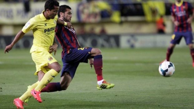 Barcelona's Dani Alves and Villarreal's Giovani Dos Santos fight for the ball during their Spanish first division soccer match at the Madrigal stadium in Villarreal where the banana-throwing slur took place.