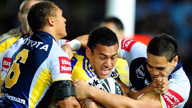 Taniela Lasalo of the Eels is tackled by Ray Thompson and Antonio Winterstein of the Cowboys.