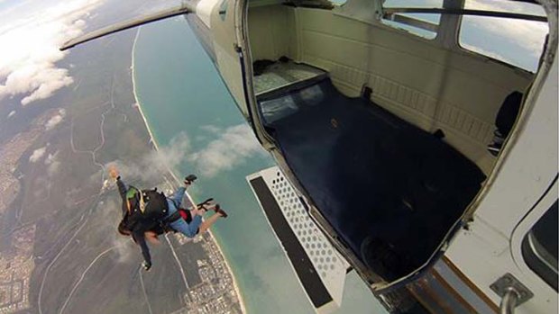 A skydiver jumps out of a Skydive Bribie plane.