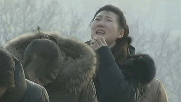 A woman cries and others bow at a monument in the North Korean capital Pyongyang after the death of dictator Kim Jong-il.